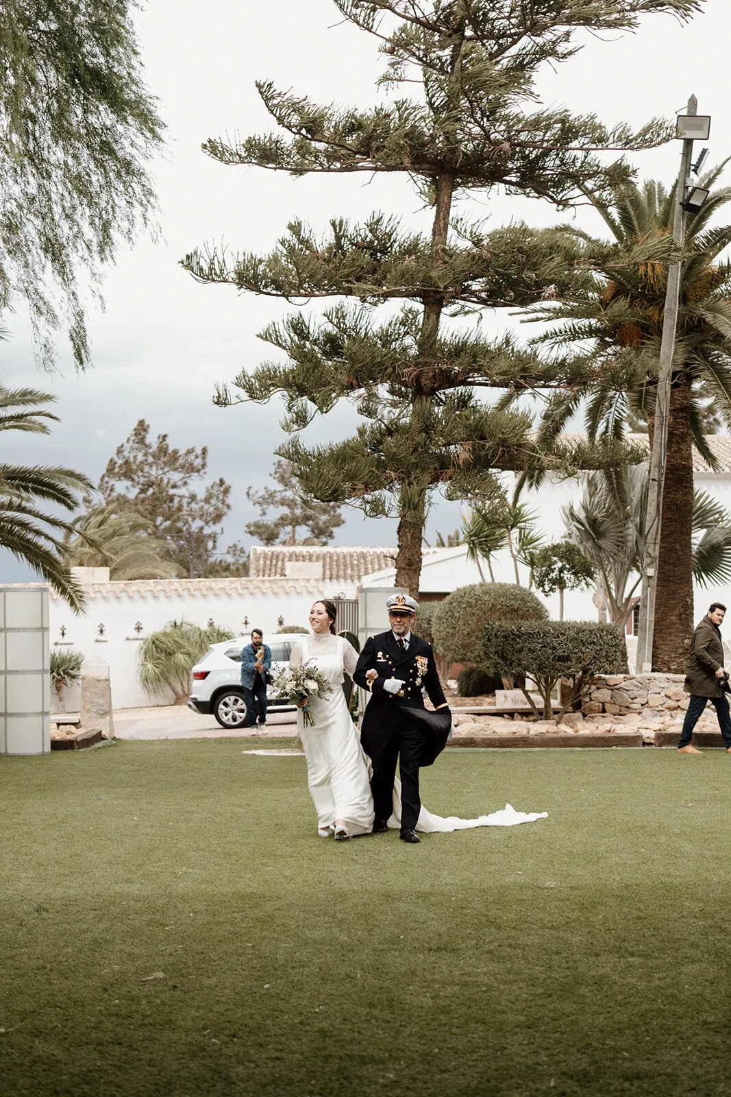La pareja diminuta en el gran jardín bajo un pino centenario