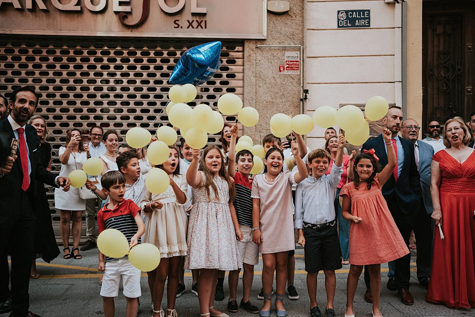 Niños con globos amarillos esperando en la calle