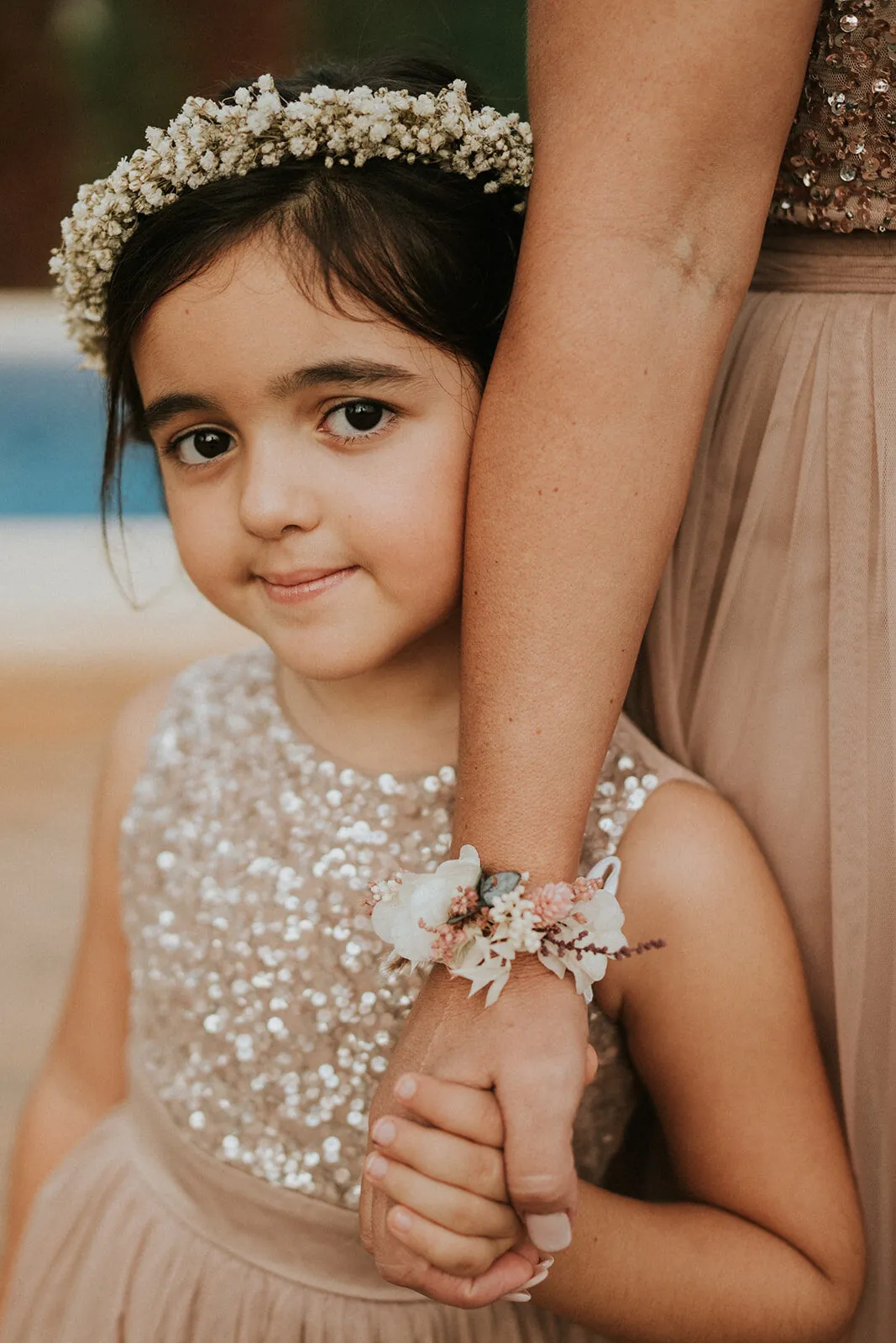 Retrato de una niña con corona de flores abrazada a su madre